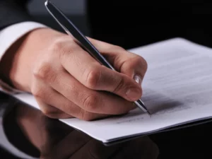 Signature de contrats et formulaires administratifs lors d'un rendez-vous.